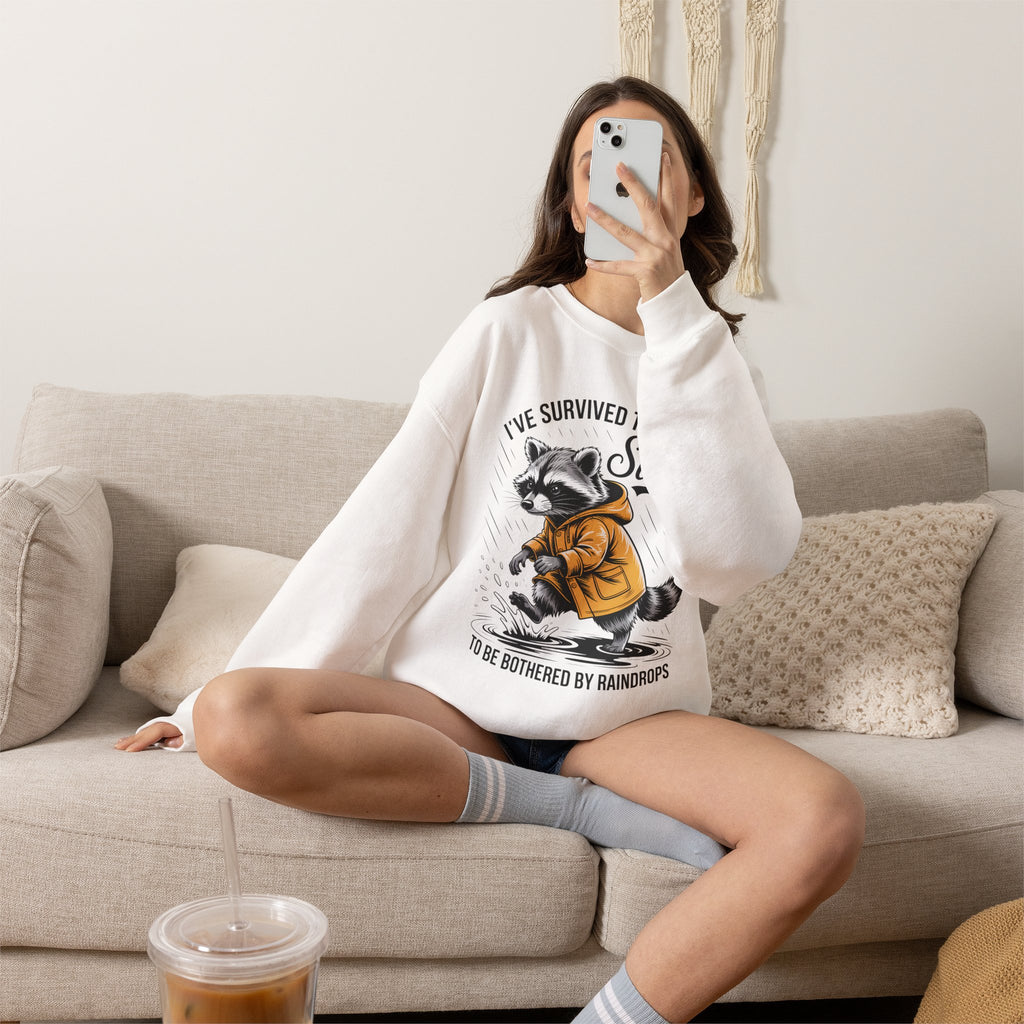 Crewneck Sweatshirt — "I've Survived Too Many Storms" Raccoon Graphic Unisex
