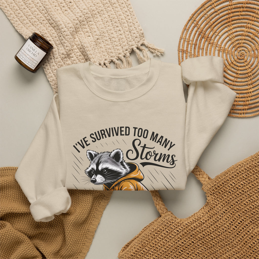 Crewneck Sweatshirt — "I've Survived Too Many Storms" Raccoon Graphic Unisex