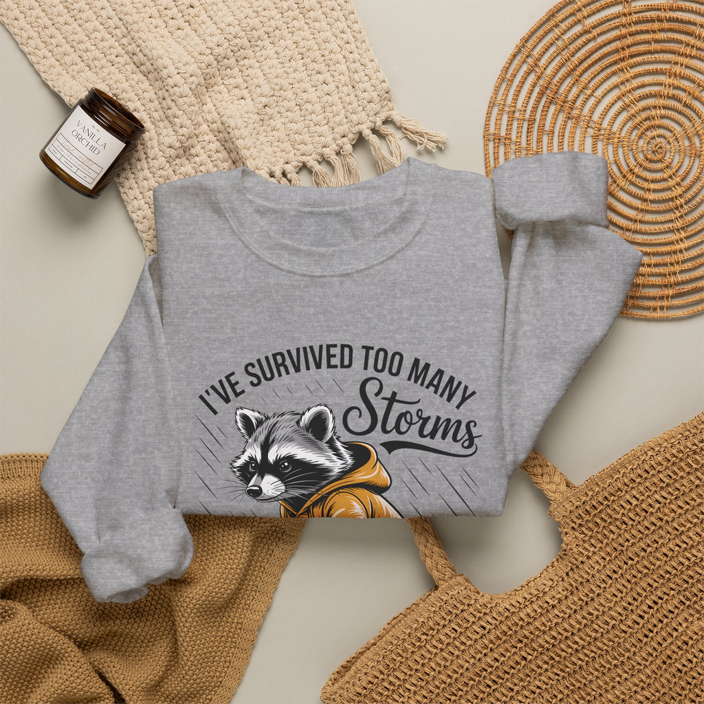Crewneck Sweatshirt — "I've Survived Too Many Storms" Raccoon Graphic Unisex