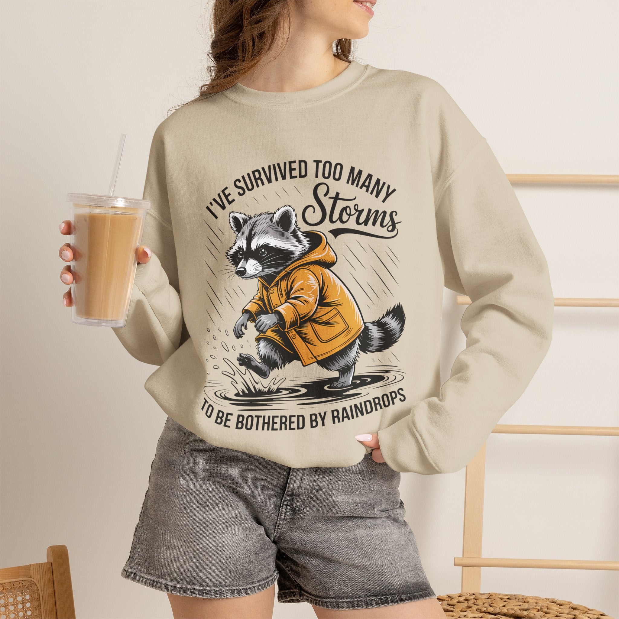 Crewneck Sweatshirt — "I've Survived Too Many Storms" Raccoon Graphic Unisex